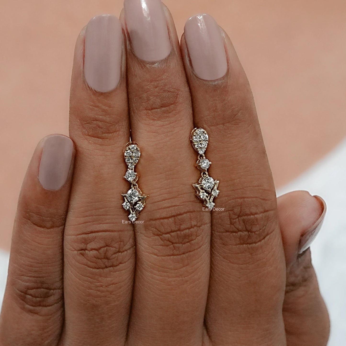 front view of round diamond dangle earrings placed on hand