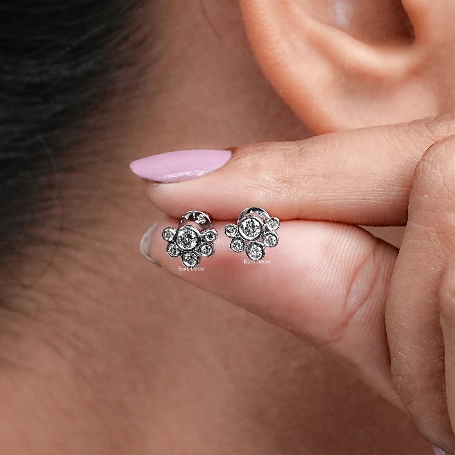 close-up view of round natural diamond bubble style ear studs shown with fingers