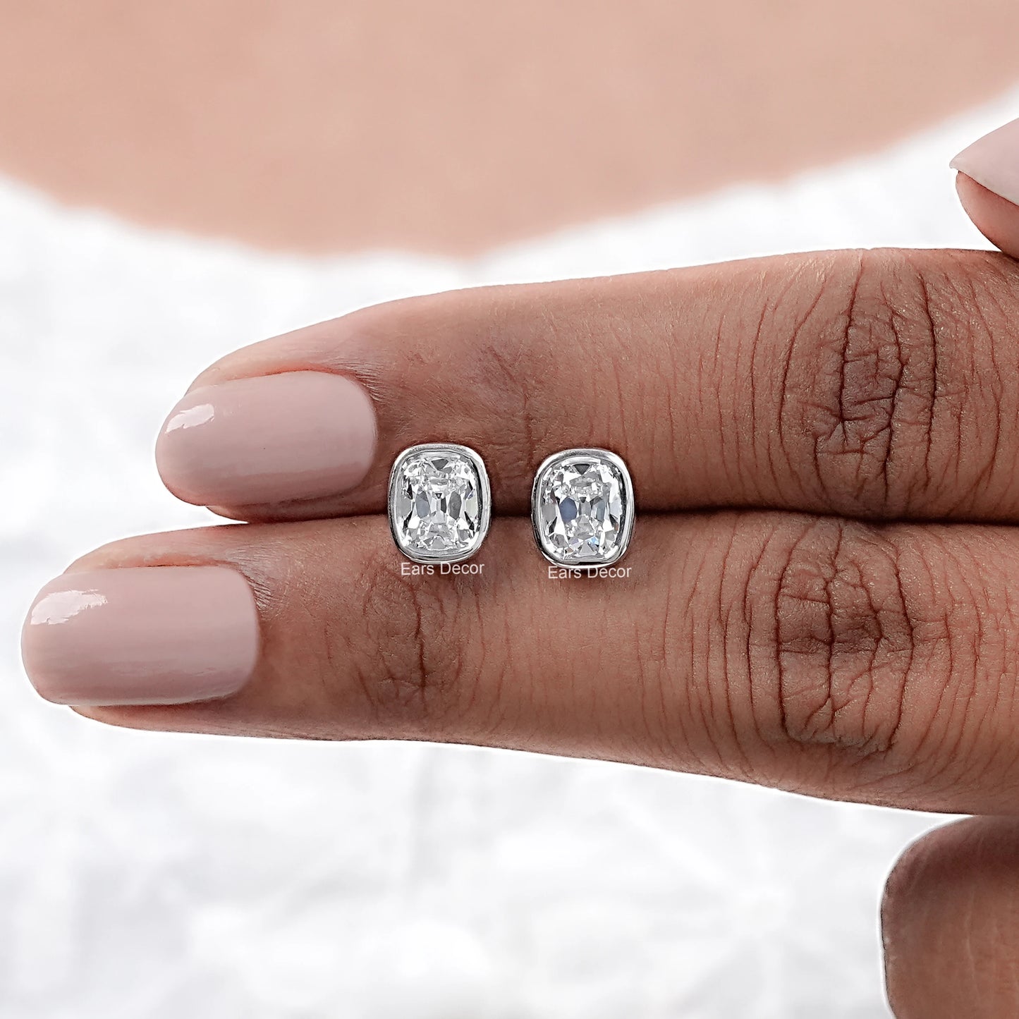Old Mine Cushion Cut CVD Diamond Stud Earrings showcased on a hand with pale nail polish.