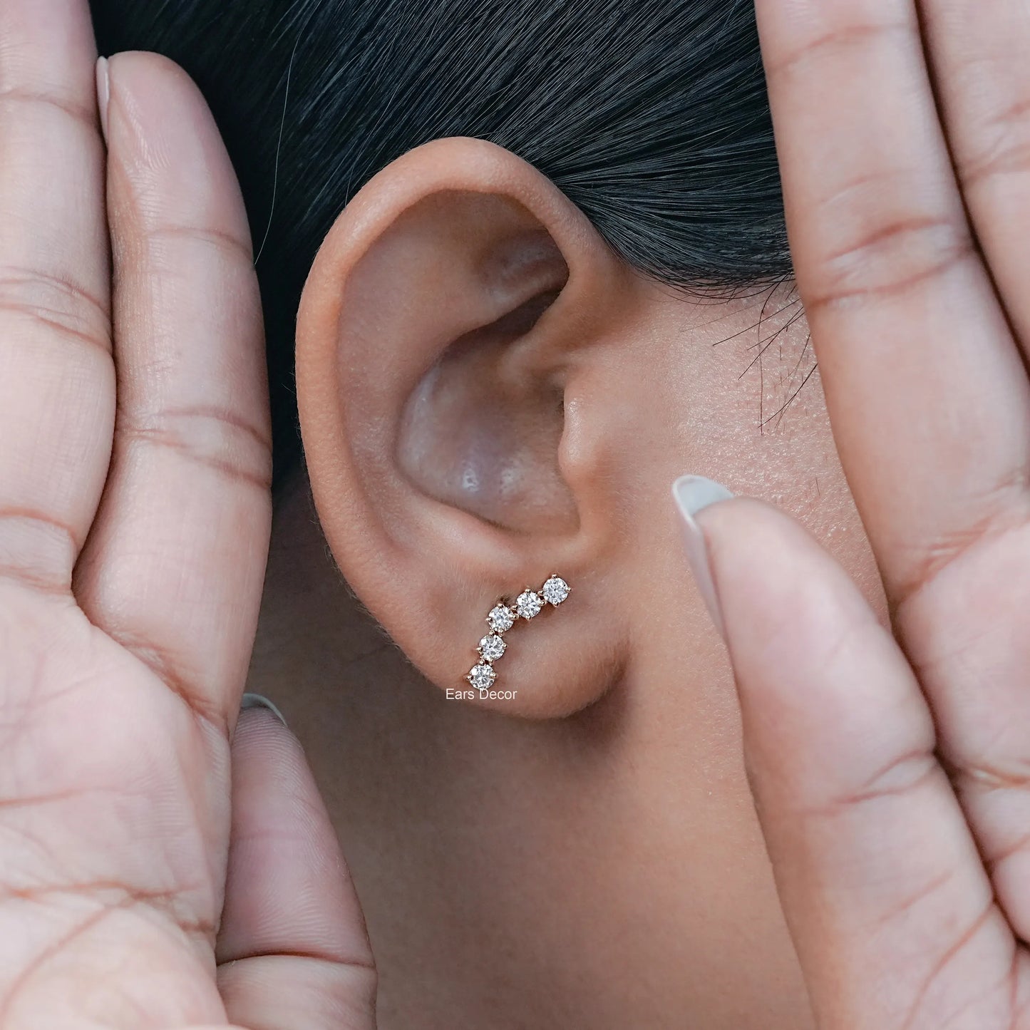natural curved diamond stud earrings worn on the ear with a polished gold finish