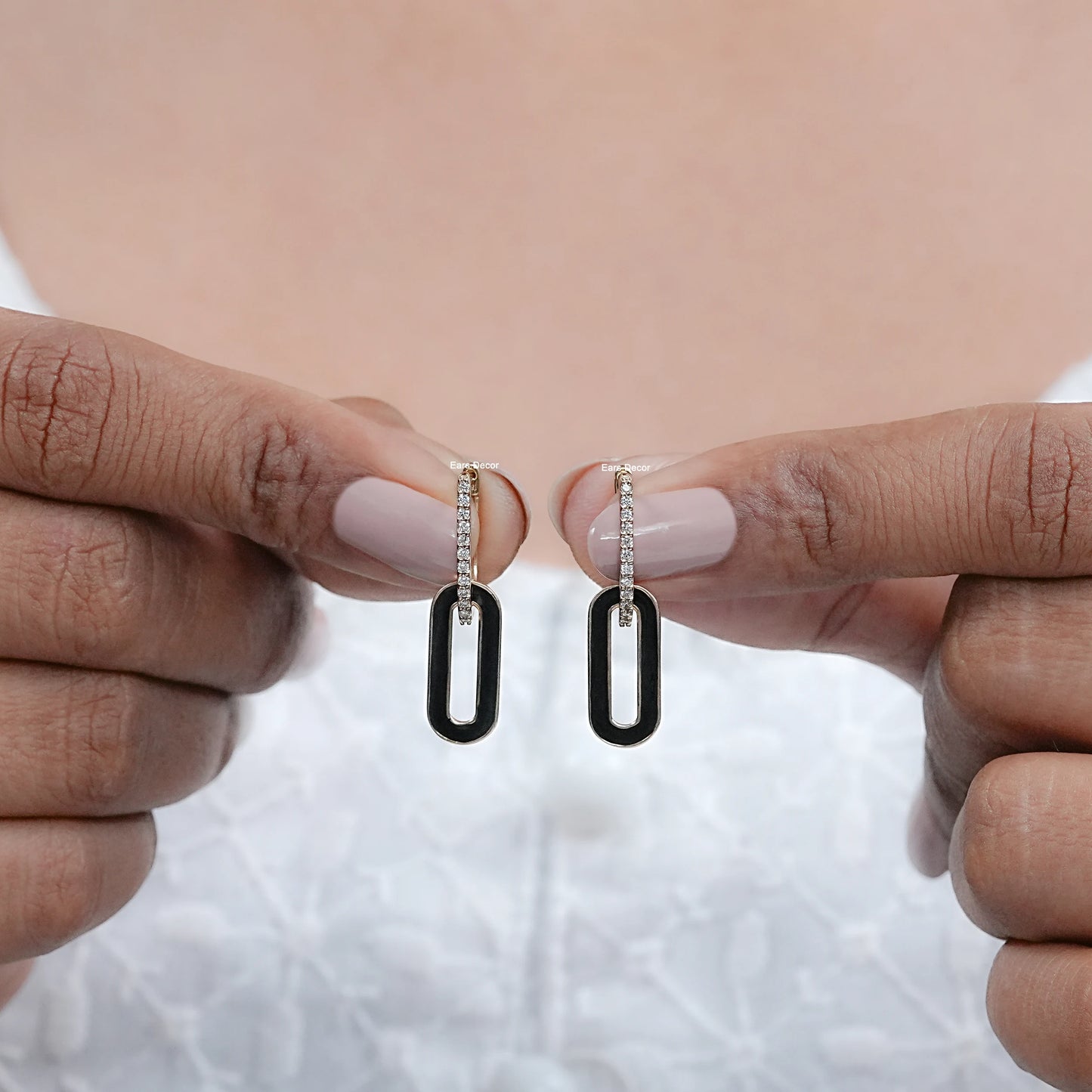 black enamel round diamond hoop earrings shown on fingers