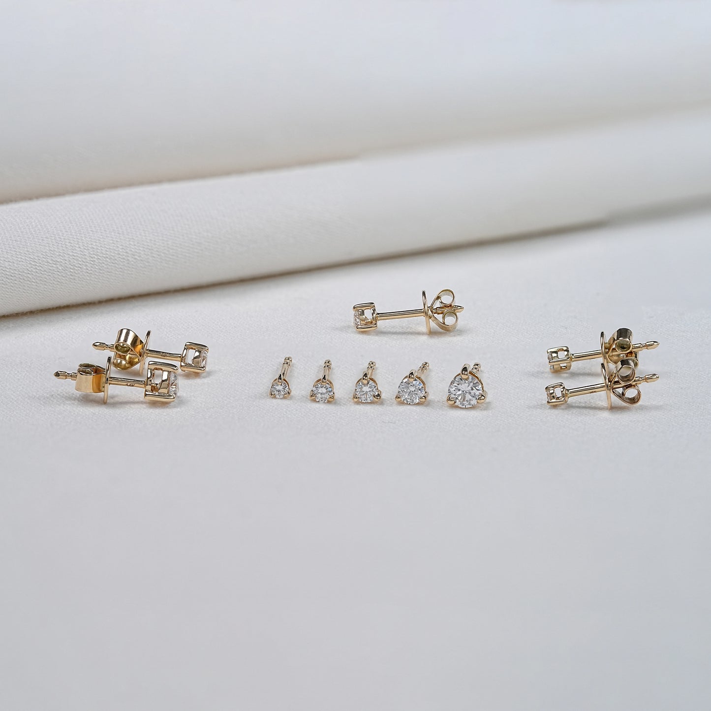 front and side view of natural diamond studs in various sizes
