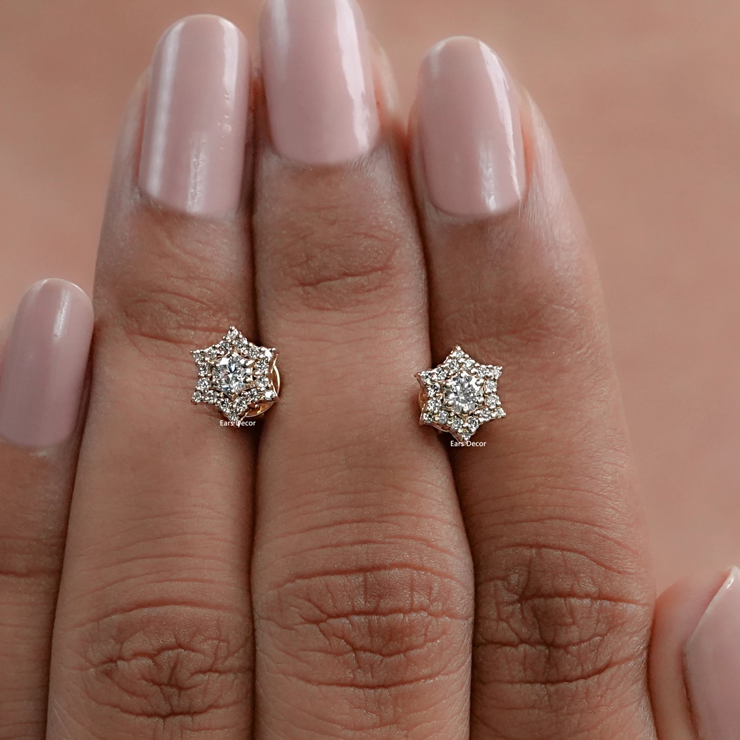 front view of round cluster diamond earrings displayed on fingers