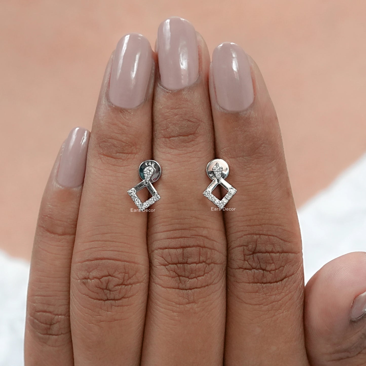 platinum square shape diamond drop earrings on fingers