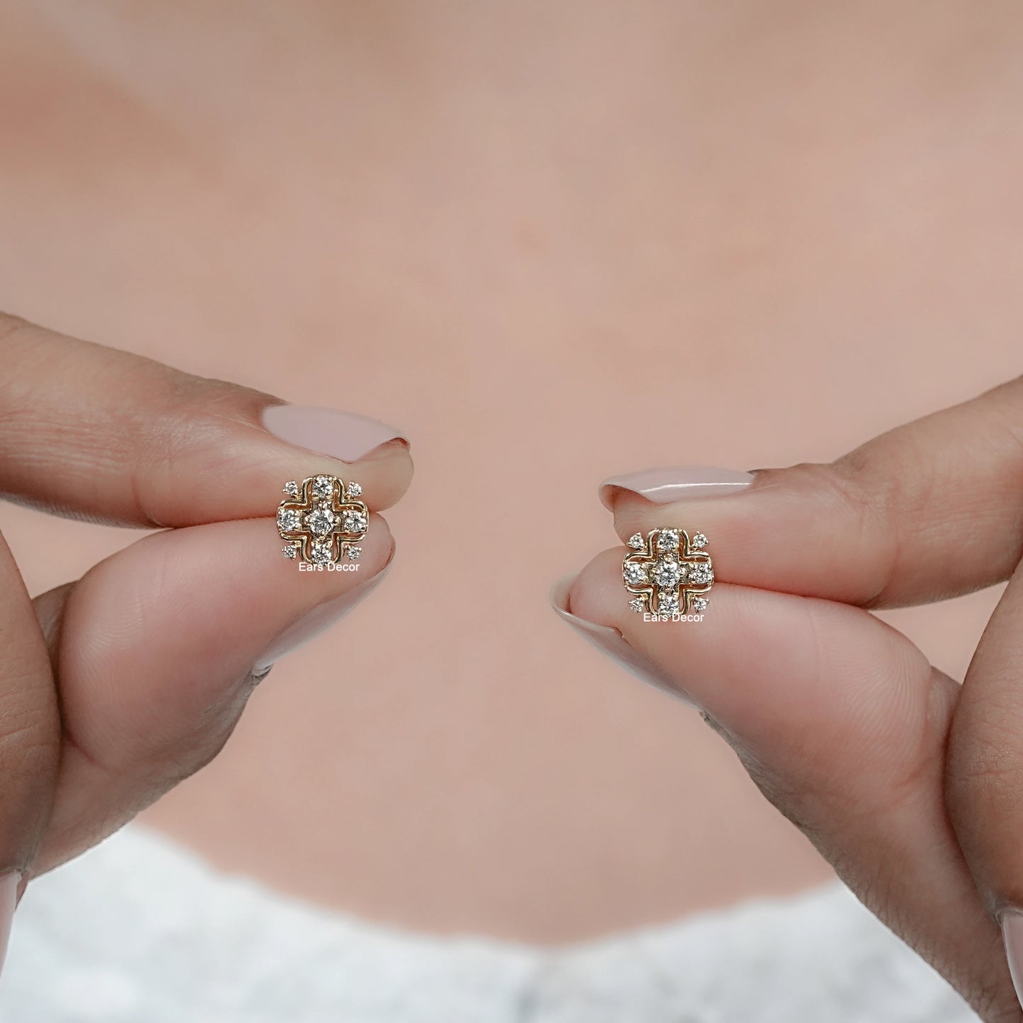 round cluster diamond earrings close up on fingers for detail