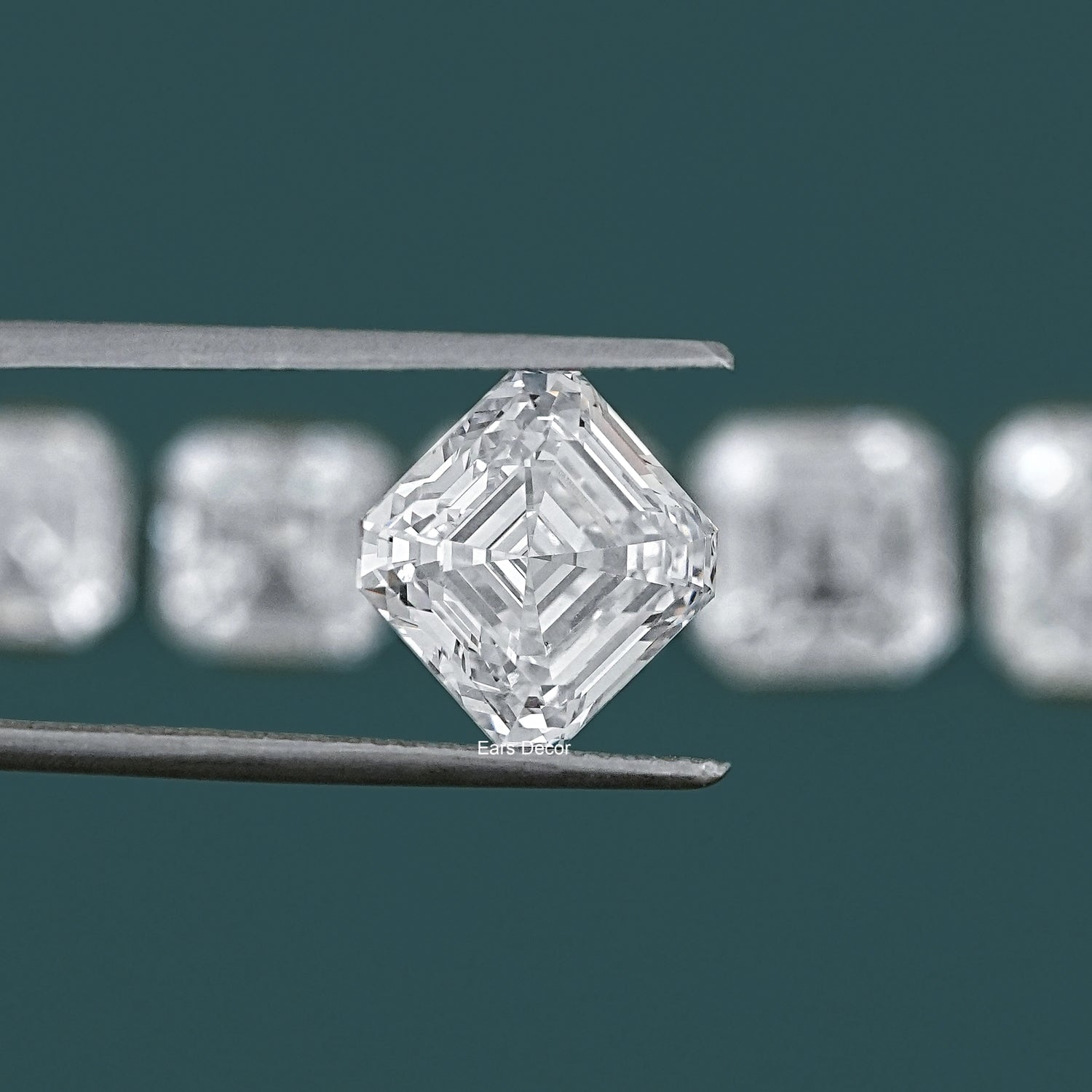 Loose asscher cut diamond stone held in tweezers close-up teal background detail shot