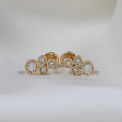 Round shape natural minimalist earrings pair on white cloth, three bezel set round stones in yellow gold