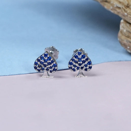 Small dainty blue crystal heart stud earrings women silver spade shape pave design matching pair close-up product shot blue pink pastel background