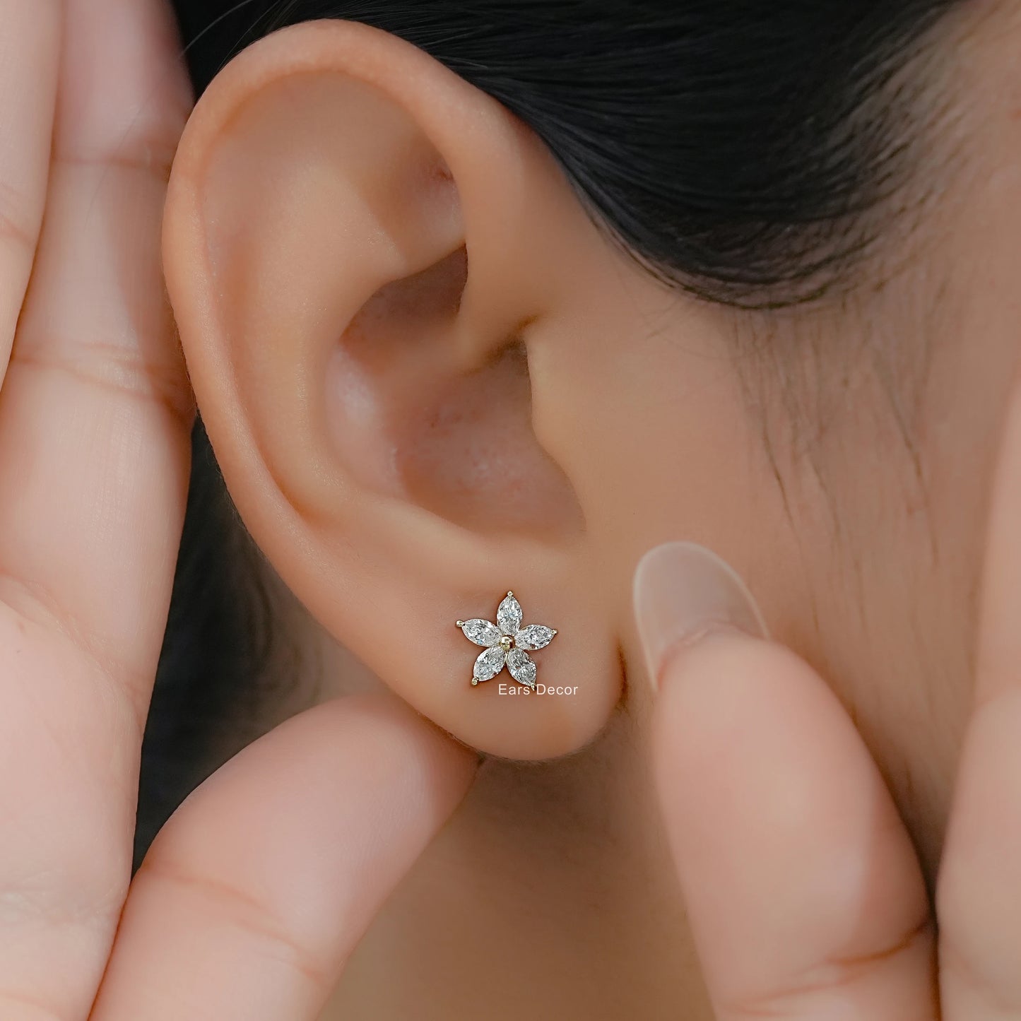 Women’s marquise diamond flower studs in yellow gold worn on a model with a clean profile view.