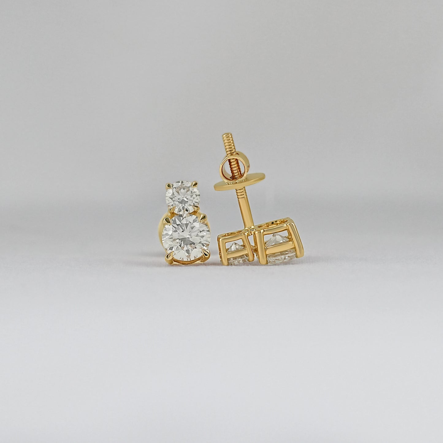 Round brilliant cut double diamond stud earrings 14k yellow gold front and back view grey background close-up product shot screw post detail