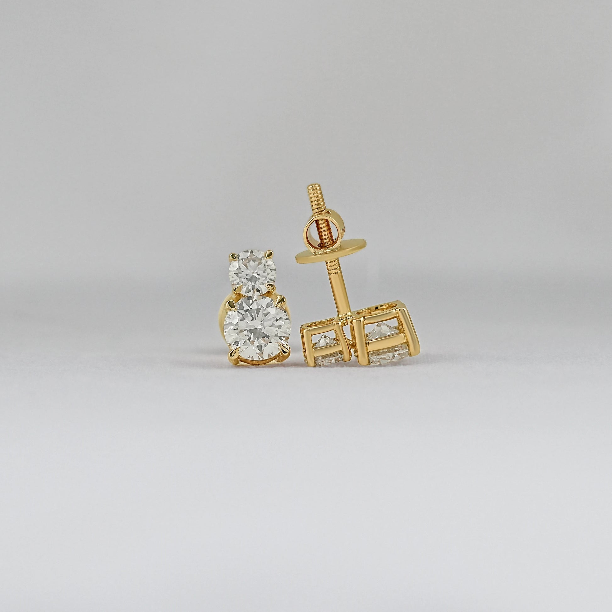 Round brilliant cut double diamond stud earrings 14k yellow gold front and back view grey background close-up product shot screw post detail