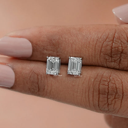 Emerald cut lab grown diamond halo studs captured in the light, showcasing precise step cut facets framed by a luminous halo of delicate diamonds.