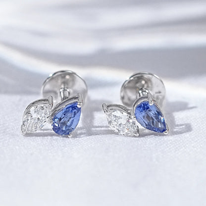 Dainty pear cut sapphire stud earrings diamond leaf design silver white gold blue teardrop clear marquise pair flat lay white linen