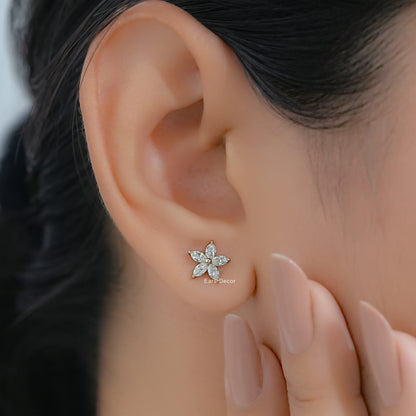 Marquise and pear shape diamond stud earrings on a model with dark hair and nude pink nails.