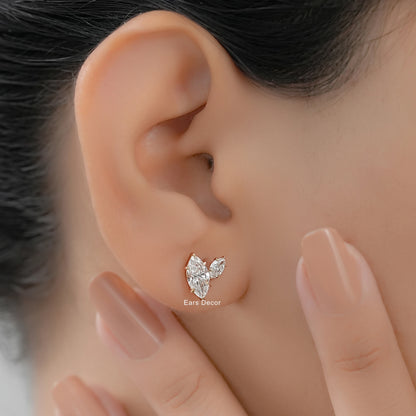 Close-up of a model wearing a marquise and pear shape diamond stud earring in a minimalist gold setting.