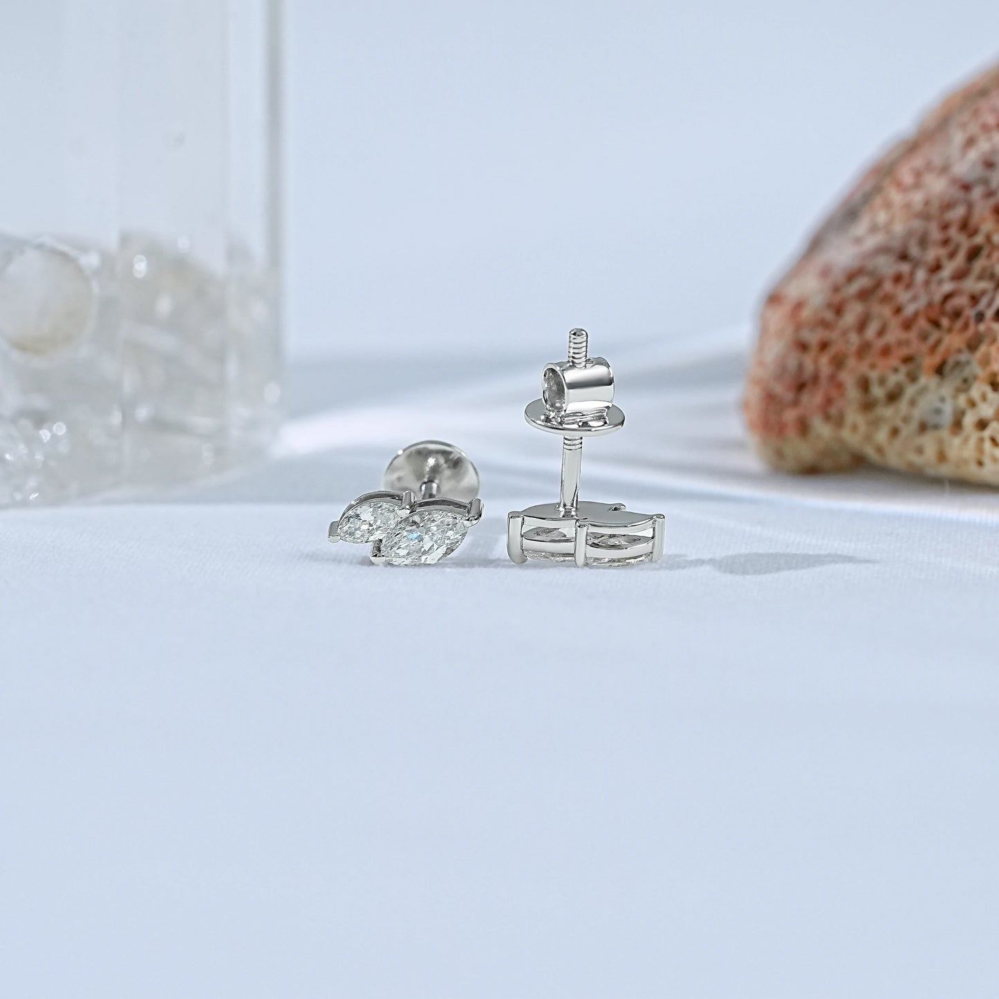 Small double marquise diamond stud earrings second piercing front and back view showing white gold butterfly clasp post detail soft background