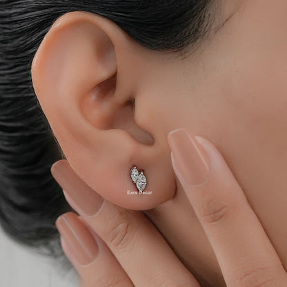 Minimalist white gold toi et moi stud earrings worn on model ear close-up dark hair nude pink nails hand touching cheek warm skin