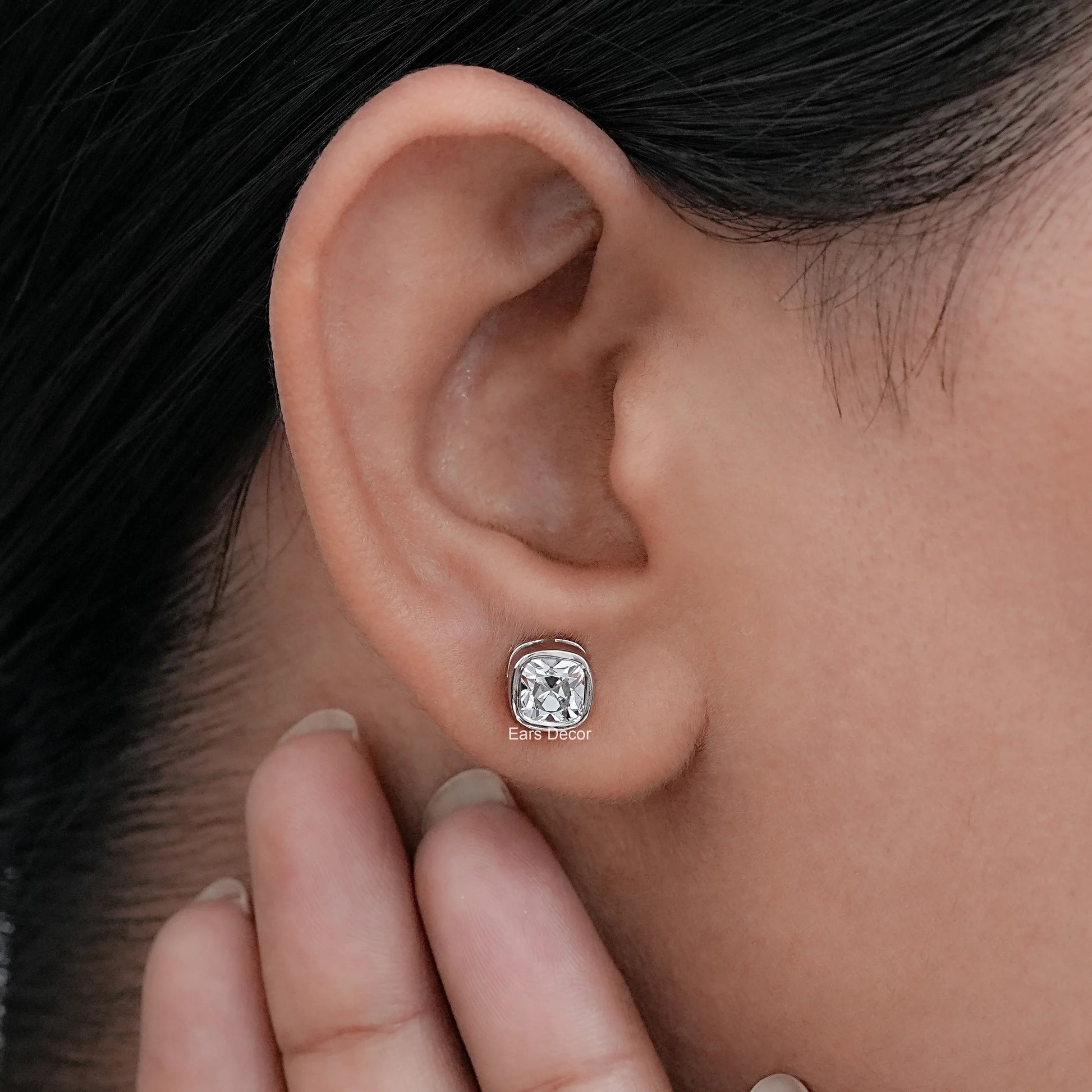 Close-up of a woman wearing lab diamond square old mine cushion cut stud earrings with 925 silver setting.