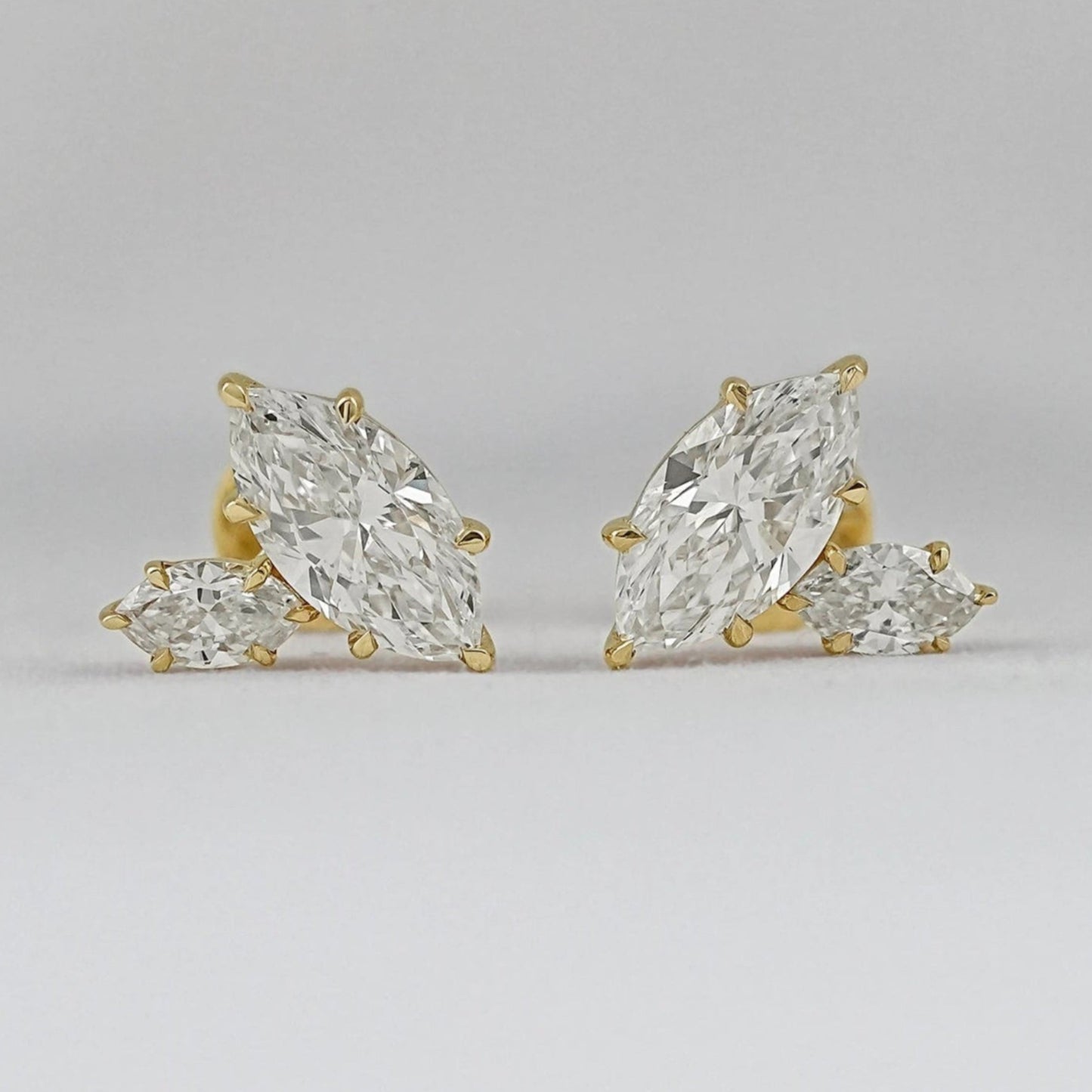 Marquise cut Toi et Moi diamond stud earrings in 14k yellow gold for women brilliant cut diamonds prong setting detail