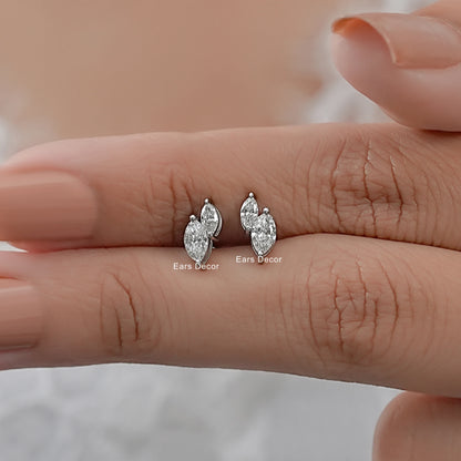 Toi et moi lab diamond stud earrings two marquise stones held between fingers size reference nude pink nails warm skin close-up
