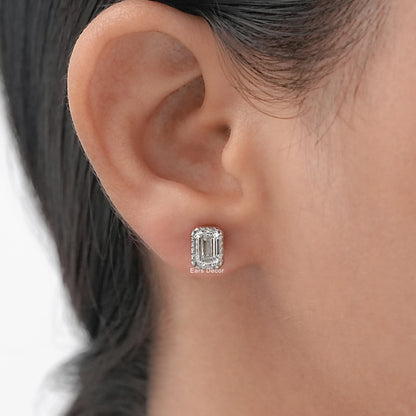 Emerald cut bezel set diamond studs worn on model's ear, white gold luxury close-up shot