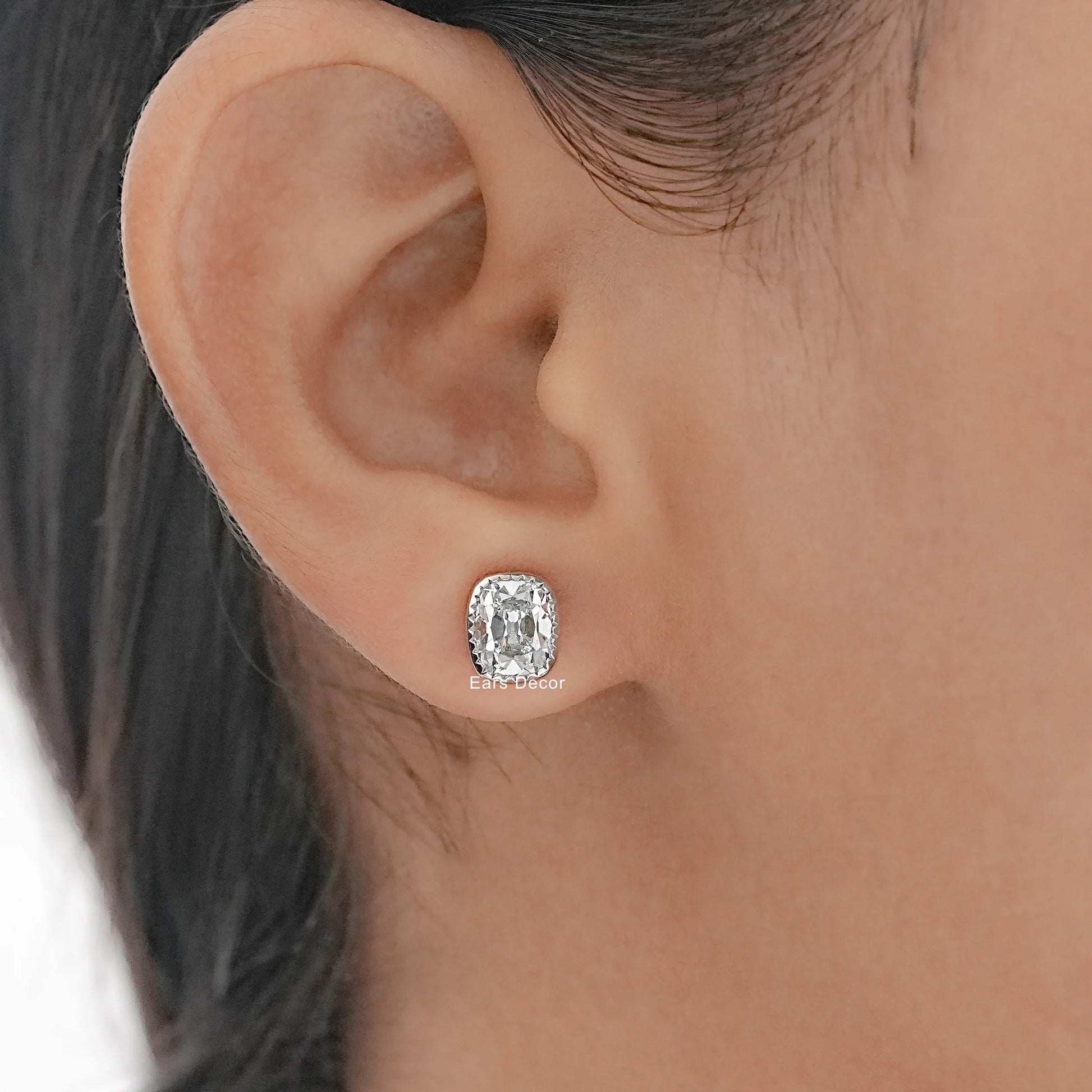 Square cushion cut diamond stud earrings white gold minimalist bezel design worn model ear dark hair warm skin side profile