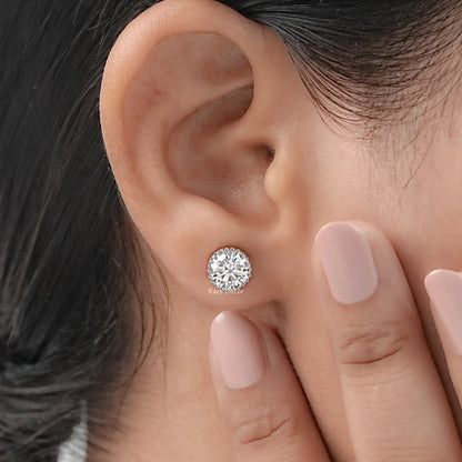 1 carat total weight moissanite stud earrings pair rose gold worn on model ear nude nails close-up