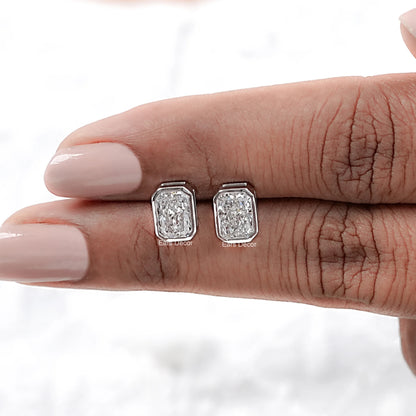 Radiant cut solitaire stud diamond earrings pair on model's fingers nude pink manicure