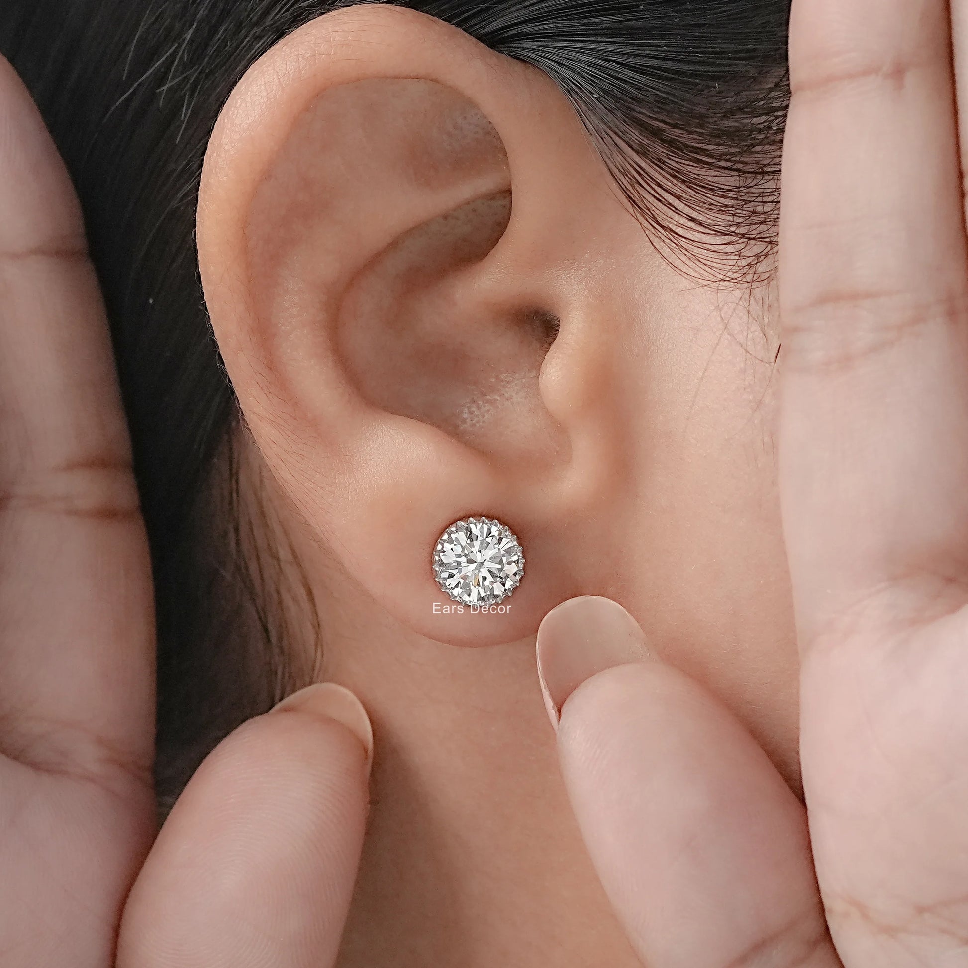Hypoallergenic moissanite stud earrings white gold setting worn on model ear hands framing close-up