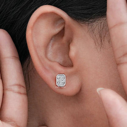 Bezel set moissanite diamond stud earring worn on model's ear, white gold close-up shot