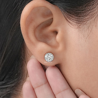 Screw back moissanite stud earrings secure fit white gold worn on model ear hand pose close-up