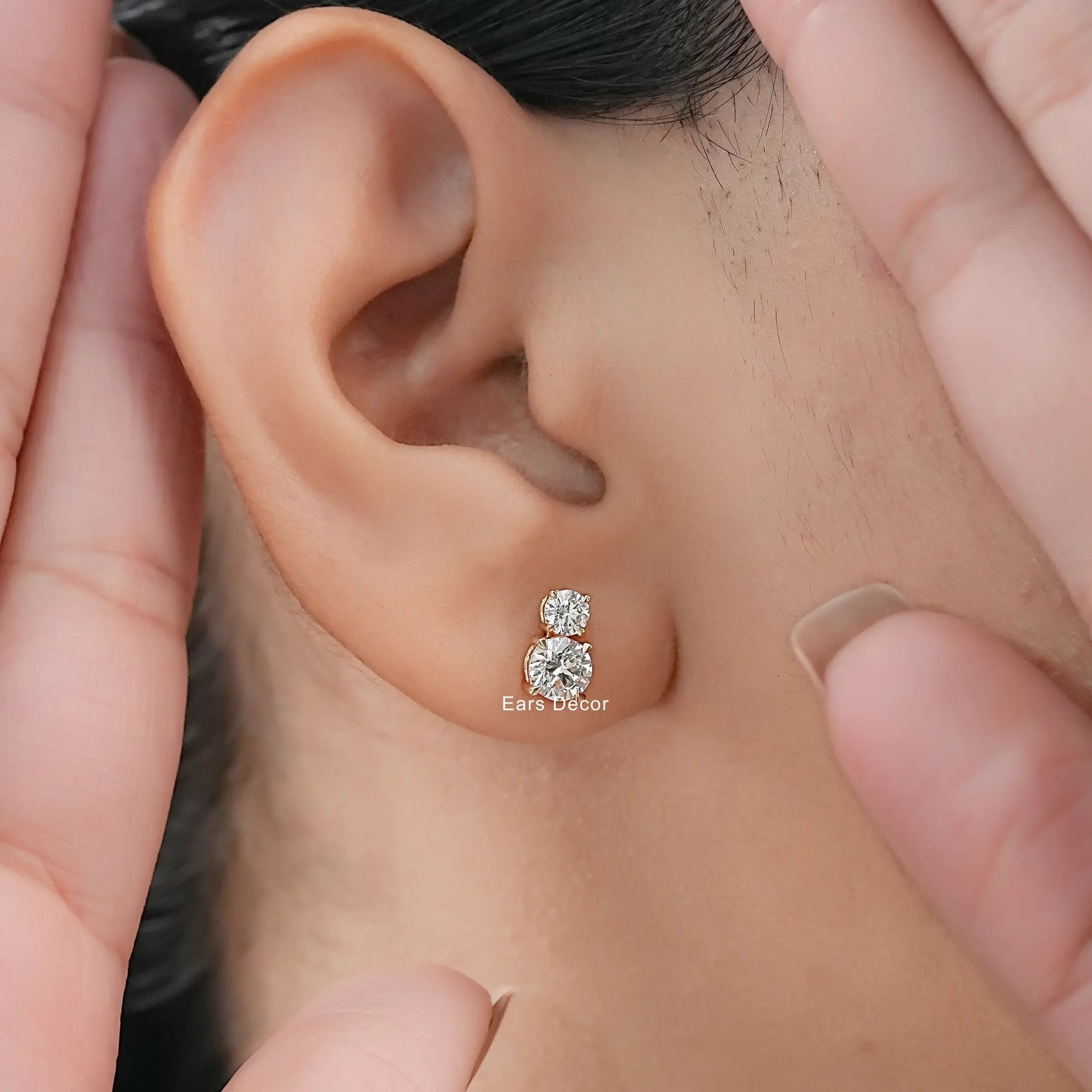 Classic two tier diamond earrings women solid gold setting worn on model ear close-up dark hair warm skin both hands framing face