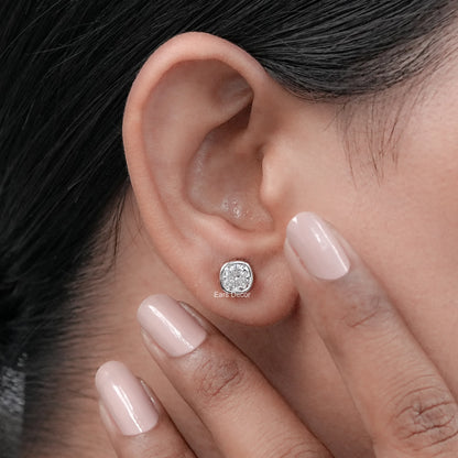 Classic moissanite bezel set solitaire stud earring worn on model's ear nude pink nails