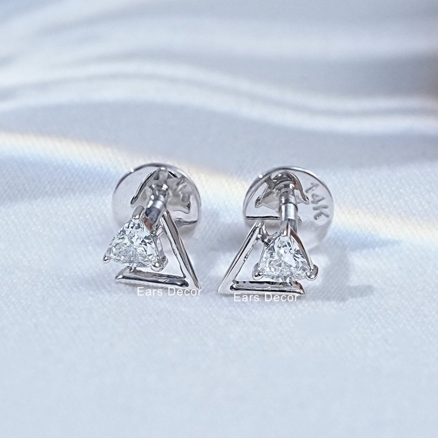 Two dainty 14k white gold triangle stud earrings sparkling clear crystal stone open geometric shape matching pair soft background